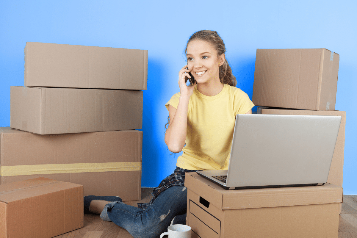 graphic young adult sitting surrounded by moving boxes
